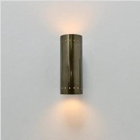 Perforated Brass Wall Sconce - Modern Cylinder Lamp shown mounted, featuring a sleek cylindrical brass design and ambient glow.