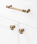 Ten Pack One And One Quarter Inch Antique Brass Kitchen Cabinet Knobs for cabinets, drawers and bathroom hardware on white doors.