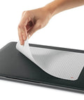 Precise Mouse Pad With Repositionable Adhesive Back For Optical Mice At High Speeds shown being applied to a laptop.