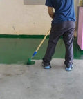 Person applying epoxy on floor wearing Epoxy Floor Spiked Shoes For Easy Garage Floor Coating Installations, 0.75 Inch Spikes