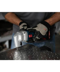 Person using 18V 16 Gauge Nibbler With Brushless Motor And Rotating Die Holder for cutting metal sheet, front view.