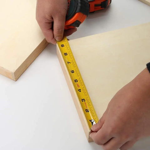 Hands using Bulk Six Pack 25 Ft Tape Measure With Easy Read Fractions One Eighth Increments for woodworking project.