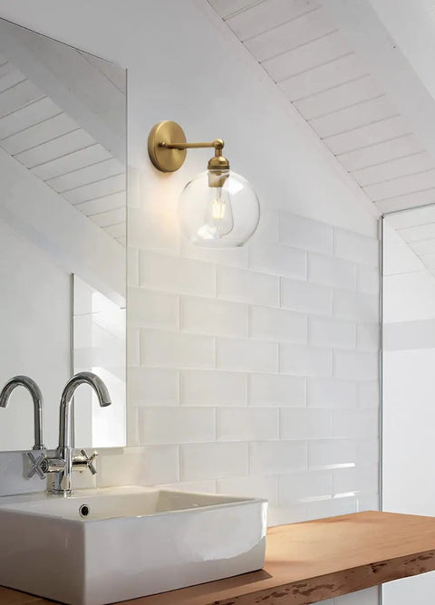Bathroom scene with Brass Boho Vanity Light Vintage Gold Wall Sconce above sink, featuring glass shade and vintage charm.
