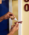 Crystal Clear Super Glue Instant Bond Adhesive Hella Tough 20 Gram Bottle being applied to red object for home repairs.