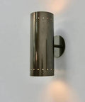 Perforated Brass Wall Sconce - Modern Cylinder Lamp attached to wall, showcasing sleek design and light patterns.