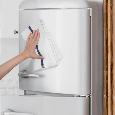 Person using Value Pack Of 36 Absorbent 16x19 Inch Terry Cloth Cleaning Rags For Home And Business on a refrigerator door.