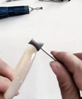 Person using Six Piece Concave Arc Diamond Burr Set Coarse Grit Diamond Mounted Grinding Bits for jewelry making with rotary tool.