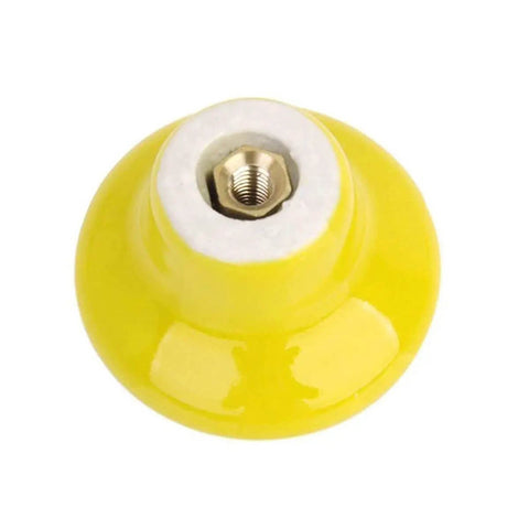Close-up of durable yellow ceramic round cabinet knob, 1.25 inches high, suitable for dressers, kitchens, closets, and cupboards in total room glow up.