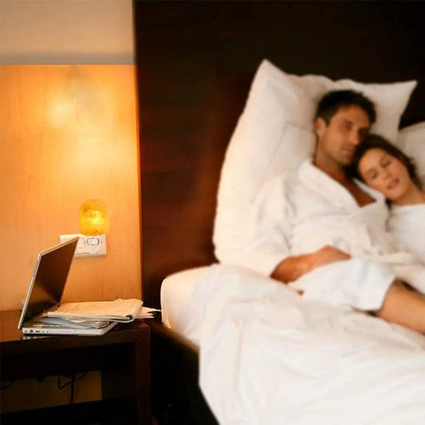 Himalayan Salt Lamp Night Light Plug In With 360 Degree Rotatable Wall Plug And Extra Replacement Bulbs in cozy bedroom setup.