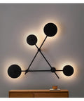 Top Shelf Round Led Wall Sconce Lighting For Bedroom Bedside Decor Featuring Smooth 360 Degree Rotation Matte Black Iron Industrial Loft Fixture Serving Clean Soft Glow on a wall with multiple circular lights.