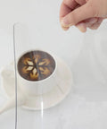 Hand holding Clear 24 By 60 Inch Table Protector 1.5mm Thick PVC Desk Mat Kid Friendly Waterproof And Easy To Clean with cup underneath