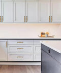 Modern kitchen with 10 Pack Antique Brass Cabinet Pulls 3 Inch Center To Center Vintage Solid Hardware installed on white cupboards.