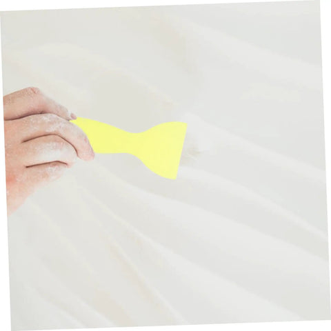 Hand smoothing Drywall Repair Putty Paste For Quick Hole Patching And Wall Mending Cream on white wall with yellow tool