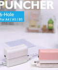 Six Hole Round Paper Punch Handheld Circle Punch For A4 A5 B5 Notebooks Scrapbooks And Planners, pocket size, shown in white and pink.