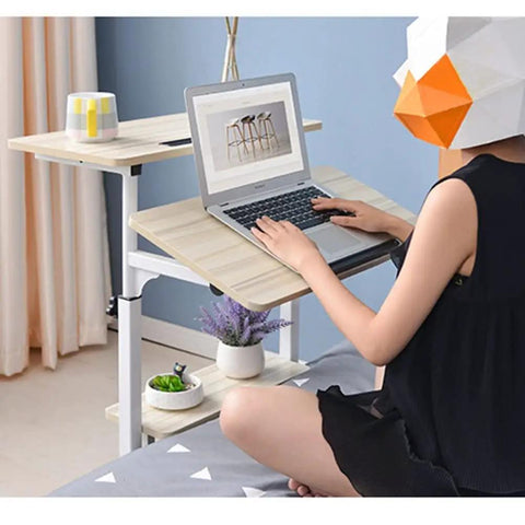 Hella Convenient Height Adjustable Overbed Table And Smooth Rolling Mobile Laptop Desk With Rock Solid Frame Sit To Stand Cart For Sofa Or Bed Side Ergonomic Computer Workstation For Home Office with laptop, plant, and mug.