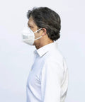 Side profile of a person wearing a Premium KN95 Face Masks for Adults, Pack of 10 Disposable Masks for All-Day Wear and Travel.