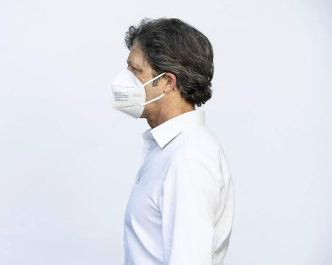 Side profile of a person wearing a Premium KN95 Face Masks for Adults, Pack of 10 Disposable Masks for All-Day Wear and Travel.