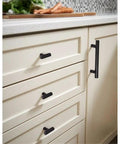 Hella Sleek Matte Black T Pull Cabinet Knobs 1.5 Inch horizontal handles on cream kitchen cabinets.