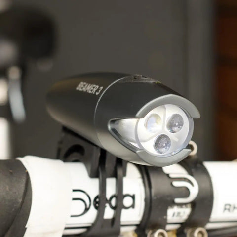 Beamer 3 Bike Headlight With Nichia LEDs Long Run Time Up To 100 Hours 220 Degree Visibility mounted on bicycle handlebars.