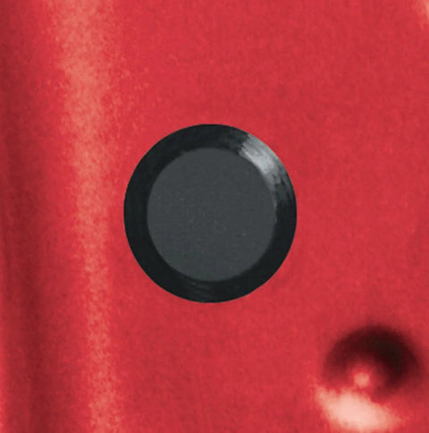Black flush mount plastic hole plug installed on red auto body panel, part of the Fifty Piece Flush Mount Plastic Hole Plug Set For Auto Body And Sheet Metal