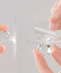 Hands holding Crystal Diamond Drawer Knobs Self Adhesive Clear Acrylic Pull Handles for drill-free installation on cabinets and furniture.