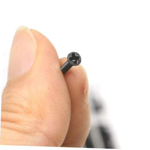 Slick Miniature Screw And Bolt Assortment Kit In Clear Storage Case For Handymen And Weekend Warriors Seeking Quick Home Repair And Fine Mechanics, showing a hand holding a black cross-headed screw.