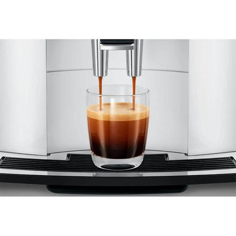 Straight Up Game Changer Automatic Espresso Coffee Maker With Easy Cappuccino Function And Premium Aroma Grinder In Sleek Piano White Finish pouring espresso into a glass.