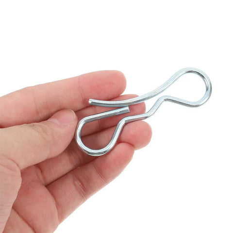Hand holding Bow Tie Lock Cotter Pin Kit With Heavy Duty Fasteners For Trailer Hitches, Lawn Mowers And Deck Clip Systems.