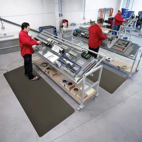 Installed anti-static floor mats on electronics assembly line with technicians at work.