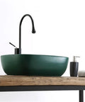 USZWBY Matte Green Rectangle Bathroom Vessel Sink - Ceramic Art Basin with Drainer Stylish Countertop Sink for Modern Bathrooms on wooden countertop.