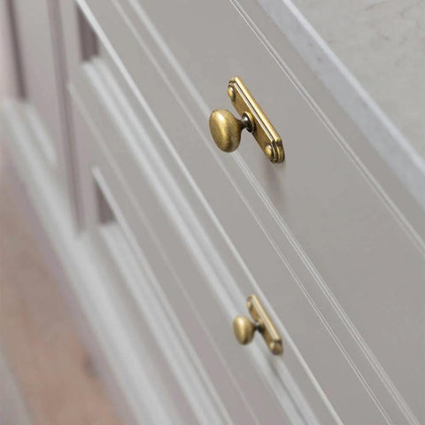 Side view of cabinet with Six Piece Set Of Antique Brass Cabinet Knobs With Industrial Backplates For Kitchen Cabinets.