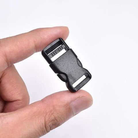 Close-up of a hand holding a black plastic half inch side release buckle, part of a 10 pack for backpack straps and DIY pet collars.