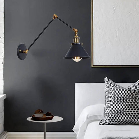 Heavy Duty Industrial Swing Arm Wall Sconce Built Tough For Living Spaces Vintage Metal Light Fixture, black and brass design above a bed.