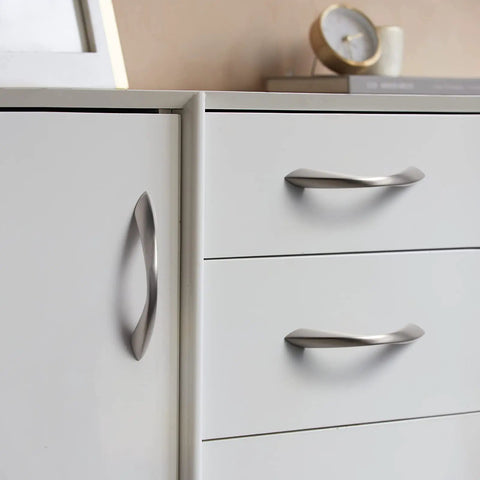 Brushed Nickel Cabinet Pulls 3 Inch Arch Twisted Silver Handles on white drawers and cabinets in kitchen