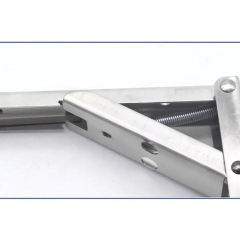 Close-up of stainless steel foldable shelf bracket with spring mechanism from Stainless Steel Foldable Shelf Brackets Wall Mounted 2 Pack Triangle Corner Supports With Spring Loaded Mechanism For Bookshelves Benches Tables Home Office Setup Built To Last Easy Install.