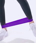Person using Five Piece Yoga Resistance Bands Set Foldable Silicone Bands for gym workouts with anti-skid grip in purple