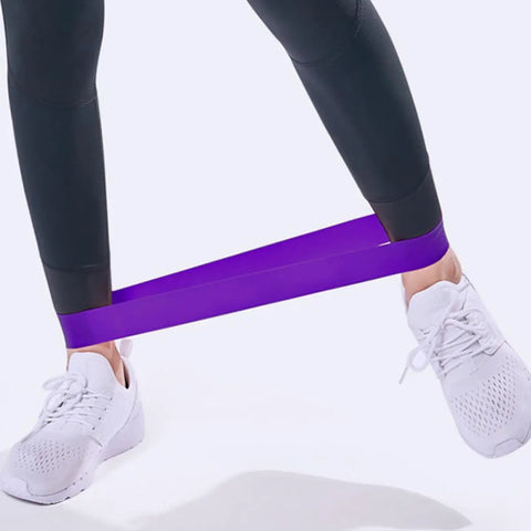 Person using Five Piece Yoga Resistance Bands Set Foldable Silicone Bands for gym workouts with anti-skid grip in purple