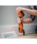 Person using 18V Cordless Oscillating Multi Tool Kit With Two 2.0Ah Batteries And Charger Quick Change Accessory System on wood floor.
