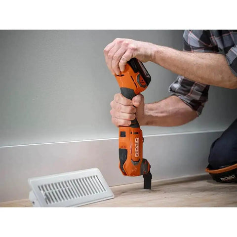 Person using 18V Cordless Oscillating Multi Tool Kit With Two 2.0Ah Batteries And Charger Quick Change Accessory System on wood floor.