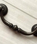 Vintage Look Bail Drawer Pulls Drop Handles 4.25 Inch Center-To-Center Dark Antique Bronze Cabinet Hardware on white wood surface