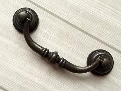 Vintage Look Bail Drawer Pulls Drop Handles 4.25 Inch Center-To-Center Dark Antique Bronze Cabinet Hardware on white wood surface