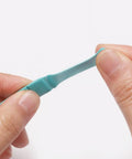 Watch Cleaning Putty Kit With Wood Sticks And Adhesive Tack, showing teal putty between fingers, for precision cleaning of tiny gears.
