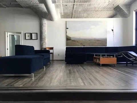 Real Deal Reclaimed Rustic Wood Stain Providing A Hella Smooth Water Based Finish That Reacts Naturally With Tannins To Create An Authentic Weathered Look Perfect For Interior Or Exterior Makeovers In A Convenient 55 Gallon Barrel applied in a modern living room with navy blue furniture.
