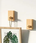 Modern Wall Mounted Coat Rack With Smooth Beige Finish sleek design holding a framed picture, showcasing entryway storage use.