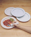 Inner Lip Plate For One Handed Dining, High Wall Red Plate with food being scooped by a hand using cutlery on wooden table.