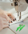 Hands threading a sewing machine with Fish Mouth Sewing Machine Needle Threader 2024 Upgrade Self Threading Tool in green, pack of 10 visible.