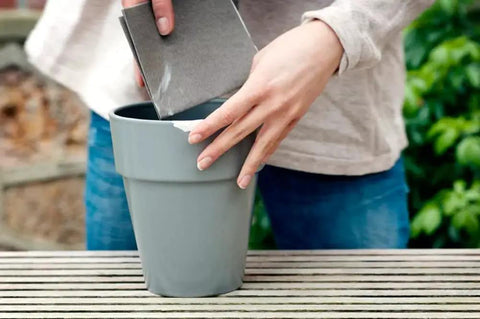 Person repairing a cracked flower pot using Epoxy Repair Putty Stick 2 Oz Hand Mixable Two Part System All Purpose Quick Set Moldable Adhesive That Bonds To Damp Surfaces And Cures Underwater For Home Marine And Plumbing Fixes 1 Pack.
