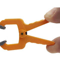 Hand holding a mini 1 inch spring clamp from the set of 20 durable polymer clamps for tight spaces with pivoting pads and rock solid grip