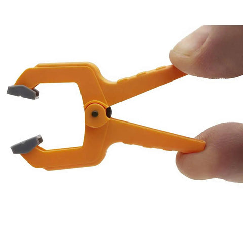 Hand holding a mini 1 inch spring clamp from the set of 20 durable polymer clamps for tight spaces with pivoting pads and rock solid grip
