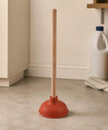 Six Inch Red Rubber Plunger With Sturdy Wood Handle Built For Light Duty Bathroom Drain And Toilet Jobs That Knock Out Stubborn Clogs Without Any Drama on a kitchen floor.